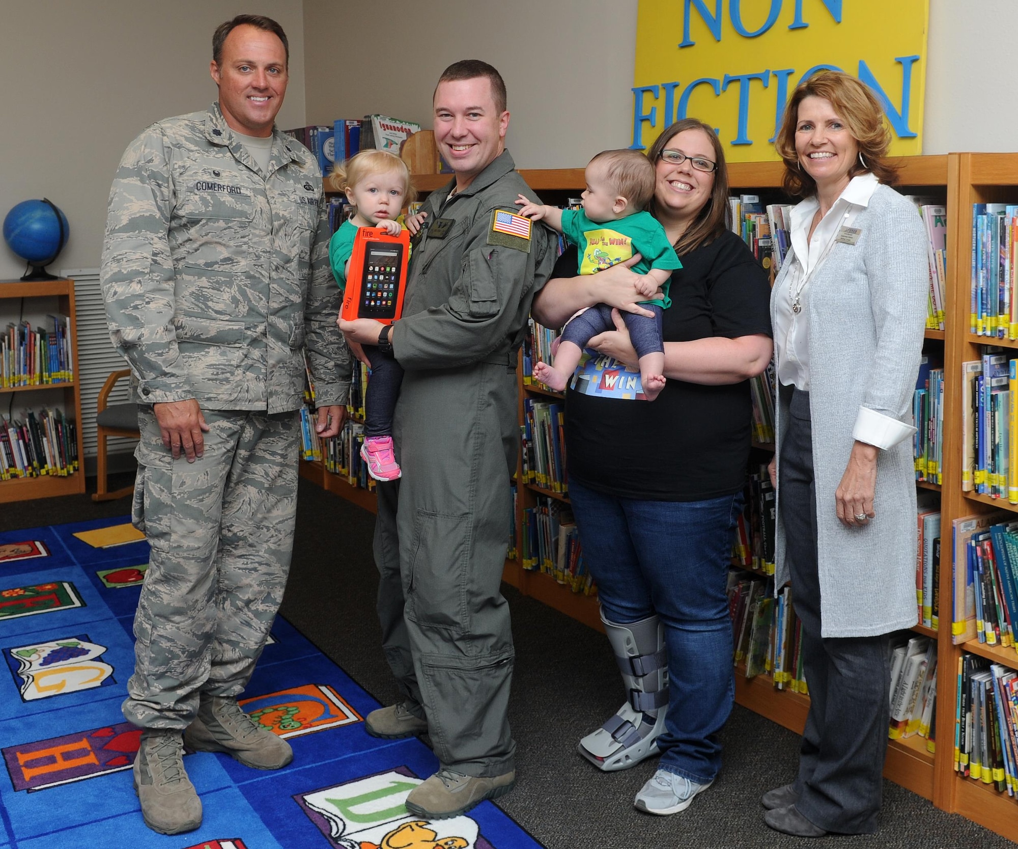 Lt. Col. Lee Comerford, left, the commander of the 1st Special Operations Force Support Squadron, poses for a group photo with the Andersen Family at Hurlburt Field, Fla., Oct. 17, 2016. Comerford presented Cassidy Andersen, left, age two, an electronic reader for placing third in her age group at the Air Force level during the 2016 Department of Defense – Morale, Welfare and Recreation Summer Reading Program. (U.S. Air Force photo by Staff Sgt. Kentavist P. Brackin)
