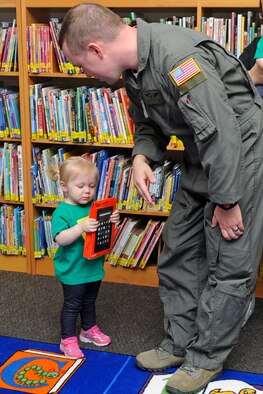 Cassidy Andersen, age two, looks at an electronic reader with her father, Senior Airman Glenn Andersen, a direct support operator with the 19th Special Operations Squadron, at Hurlburt Field, Fla., Oct. 17, 2016. Cassidy accumulated more than 1,100 minutes reading along with her parents as part of a two-month long summer reader program. (U.S. Air Force photo by Staff Sgt. Kentavist P. Brackin)