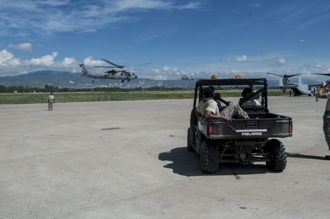 Airmen with the 621st Contingency Response Wing marshall Navy SH-60B Seahawk helicopters from the USS Iwo Jima onto the ramp at Port-au-Prince, Haiti, Oct. 17,  2016. The CRW is a part of the joint task force supporting the request for humanitarian assistance in Haiti following Hurricane Matthew. Air Force photo by Staff Sgt. Robert Waggoner
