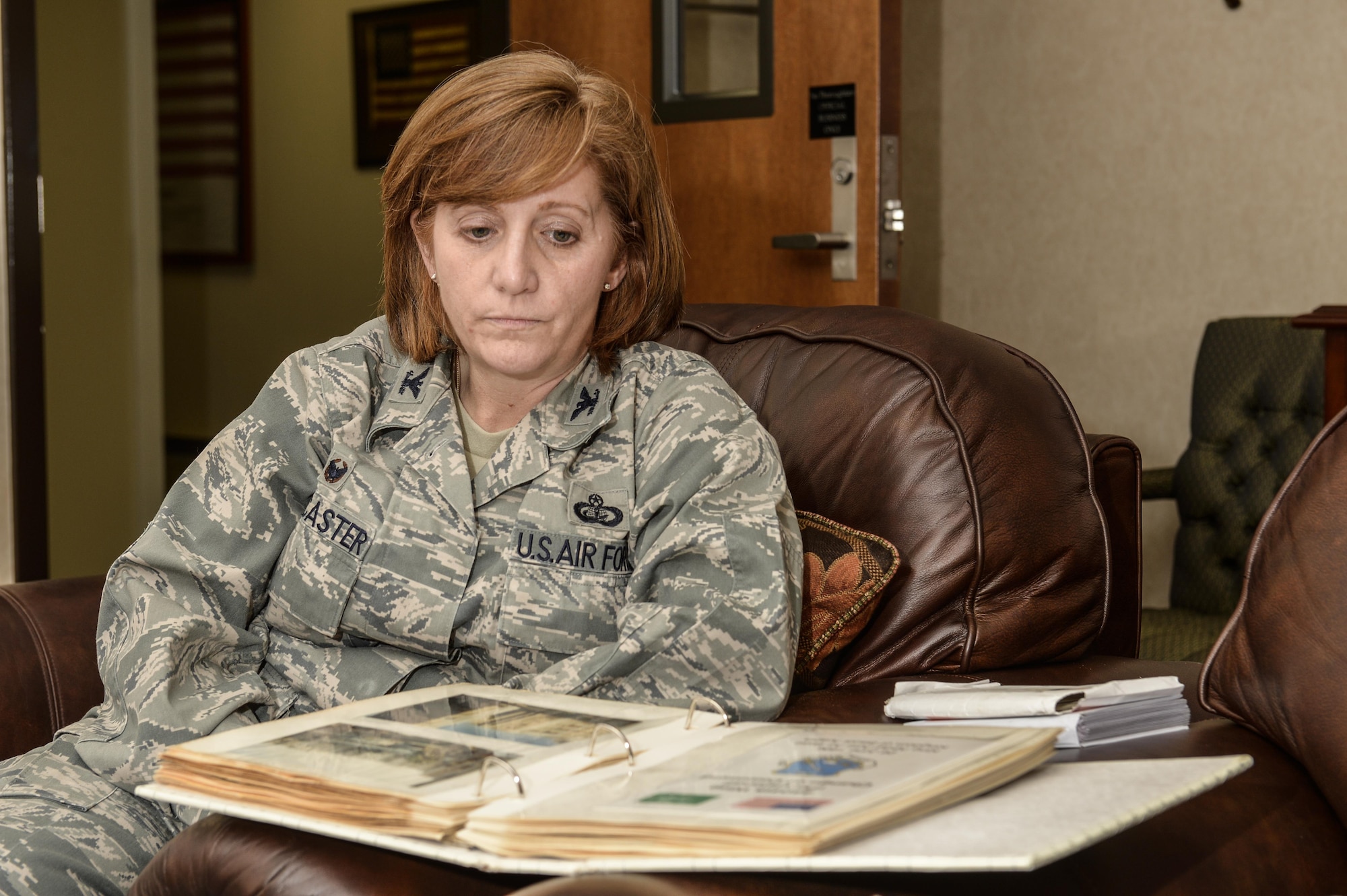 Col. Dawn Lancaster, Air Force Mortuary Affairs Operations commander, looks over photos from the Khobar Towers bombing, Sept. 21, 2016, at Dover Air Force Base, Del. Lancaster received a Purple Heart for wounds inflicted that day by shards of imploding glass. (U.S. Air Force photo by Tech. Sgt. Scott Johnson)