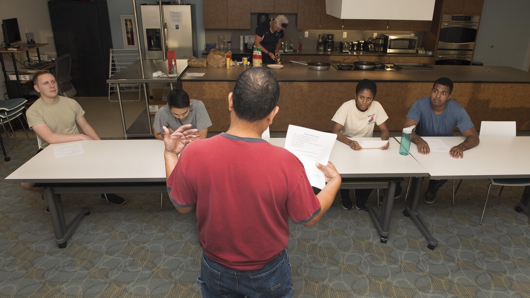 Roland Balik, 436th Airlift Wing Public Affairs photojournalist, speaks to Team Dover Airmen during a Dorm to Gourm class Oct. 11, 2016, inside the fitness center on Dover Air Force Base, Del. This Dorm to Gourm class’s theme was Mexican food. (U.S. Air Force photo by Senior Airman Zachary Cacicia)