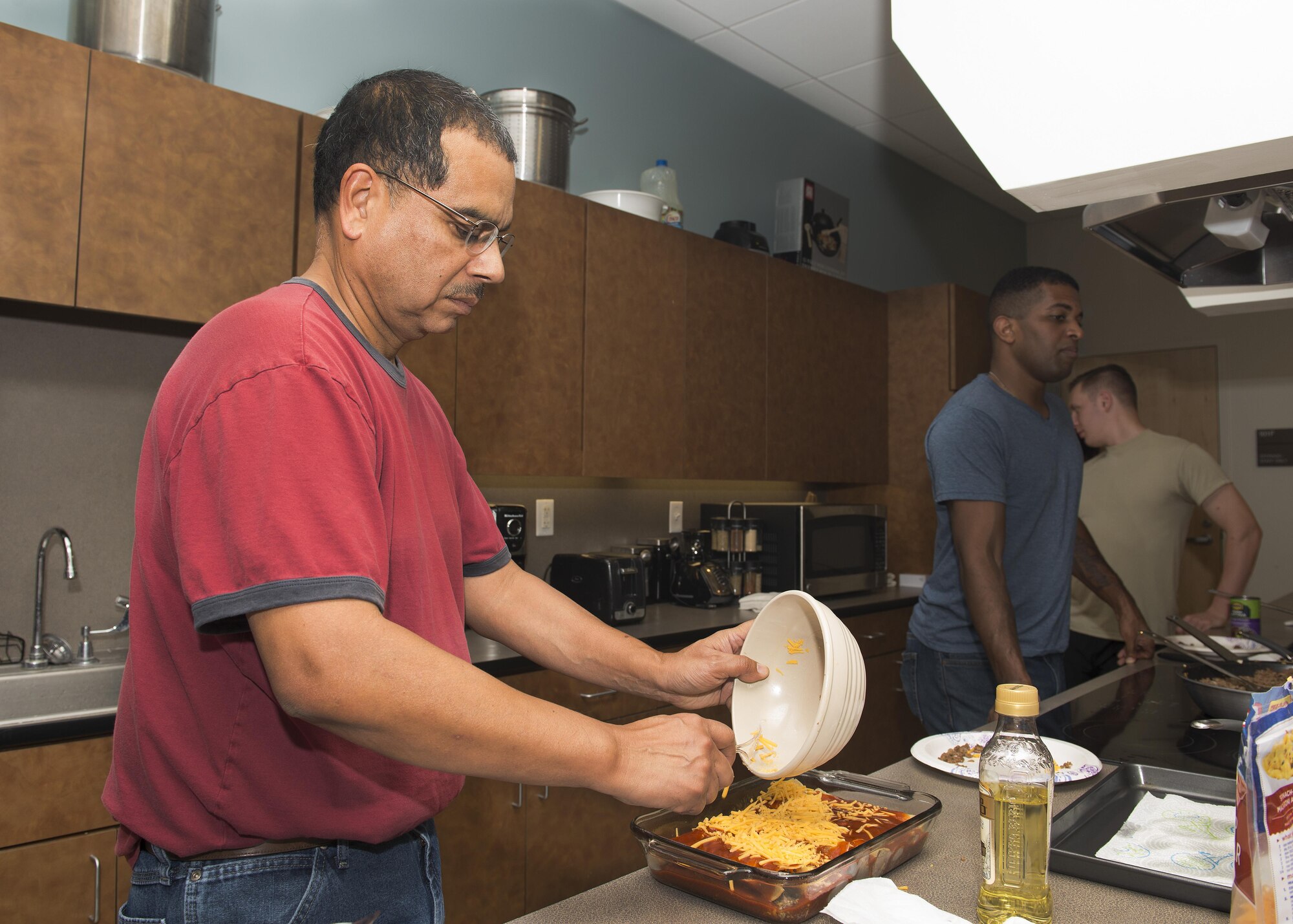 Roland Balik, 436th Airlift Wing Public Affairs photojournalist, prepares a dish of beef enchiladas during a Dorm to Gourm class Oct. 11, 2016, inside the fitness center on Dover Air Force Base, Del. Balik taught the students how to make three separate meals: breakfast, lunch and dinner. (U.S. Air Force photo by Senior Airman Zachary Cacicia)
