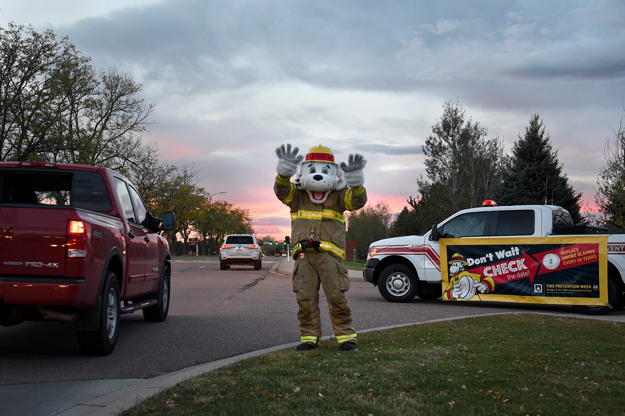 PETERSON AIR FORCE BASE, Colo. – Sparky, Peterson Fire and Emergency Services mascot, waves to passersby as they enter the north gate at Peterson Air Force Base, Colo., Oct. 11, 2016. Sparky welcomed personnel to base during National Fire Prevention Week, Oct. 10 - 15. (U.S. Air Force photo by Senior Airman Rose Gudex)