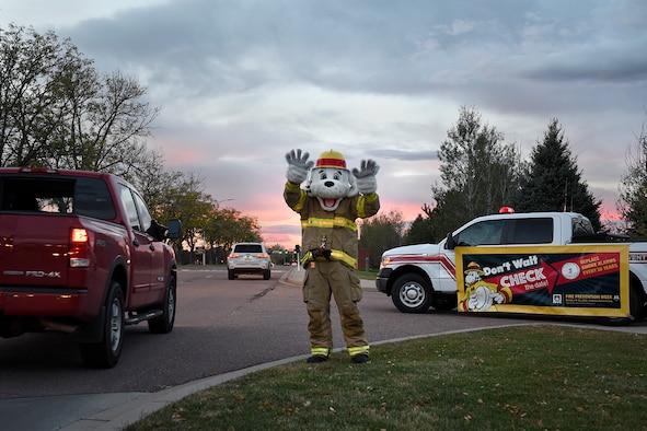 PETERSON AIR FORCE BASE, Colo. – Sparky, Peterson Fire and Emergency Services mascot, waves to passersby as they enter the north gate at Peterson Air Force Base, Colo., Oct. 11, 2016. Sparky welcomed personnel to base during National Fire Prevention Week, Oct. 10 - 15. (U.S. Air Force photo by Senior Airman Rose Gudex)