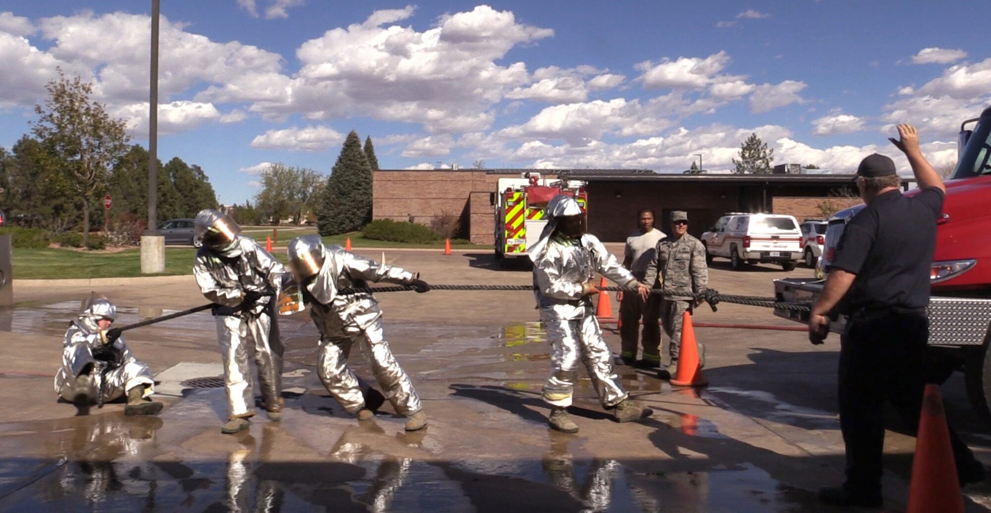 PETERSON AIR FORCE BASE, Colo. – The team from the 21st Civil Engineer Squadron structures shop pull a fire truck during the Fire Muster at the Fire Station on Peterson Air Force Base, Colo., Oct. 13, 2016. The Fire Muster was a timed event held during National Fire Prevention Week where teams of four competed in six events to get a feel for what firefighters do on a daily basis. (U.S. Air Force photo by Tech. Sgt. Joshua Arends)