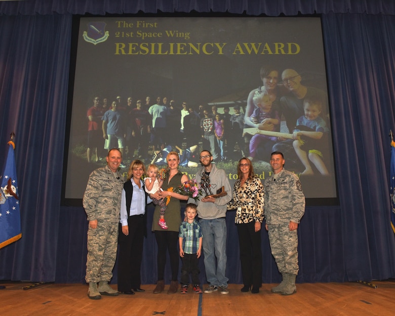 PETERSON AIR FORCE BASE, Colo. – The inaugural 21st Space Wing Resiliency Award is presented to Staff Sgt. Ryan Meston, 4th Space Control Squadron, and his family during a commander’s call at the auditorium on Peterson Air Force Base, Colo., Oct. 13, 2016. In recent years, Meston was diagnosed with two types of cancer back-to-back, but is now in remission. (U.S. Air Force photo by Maj. William Russell)