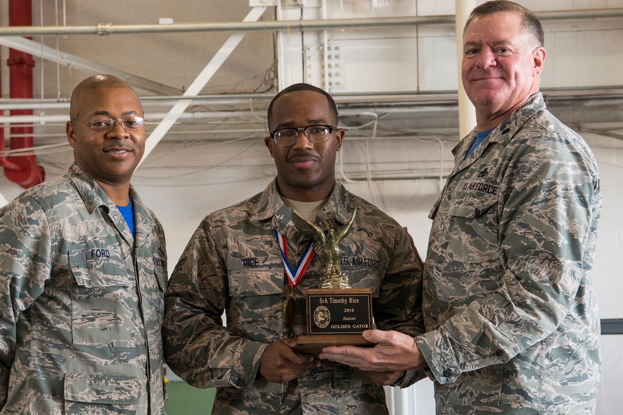 U.S. Air Force Lt. Col. Leo Kamphaus, 307th Maintenance Group commander, presents an award to Senior Airman Timothy Rice during the annual Gatorfest Awards Ceremony on Oct. 15, 2016, Barksdale Air Force Base, La. Rice is the recipient of the Junior Golden Gator award. (U.S. Air Force photo by Master Sgt. Greg Steele/Released)