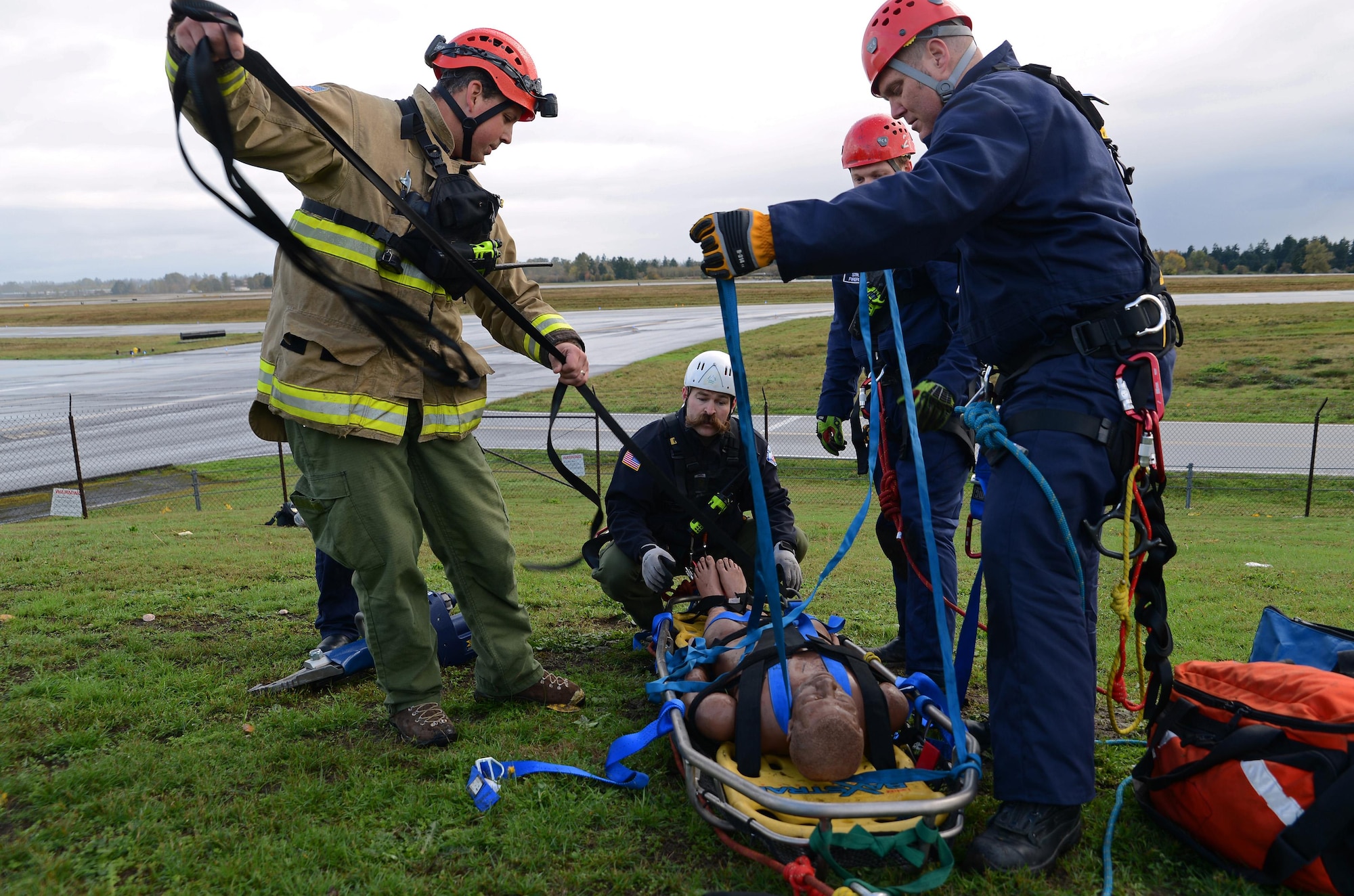 Firefighters from Joint Base Lewis-McChord Fire and Emergency Services secure a training aid to a stretcher during low-angle rescue training Oct. 17, 2016, at JBLM, Wash. More than 10 firefighters participated in the training to gain skills proficiency. (U.S. Air Force photo/Senior Airman Jacob Jimenez) 