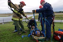 Firefighters from Joint Base Lewis-McChord Fire and Emergency Services secure a training aid to a stretcher during low-angle rescue training Oct. 17, 2016, at JBLM, Wash. More than 10 firefighters participated in the training to gain skills proficiency. (U.S. Air Force photo/Senior Airman Jacob Jimenez) 