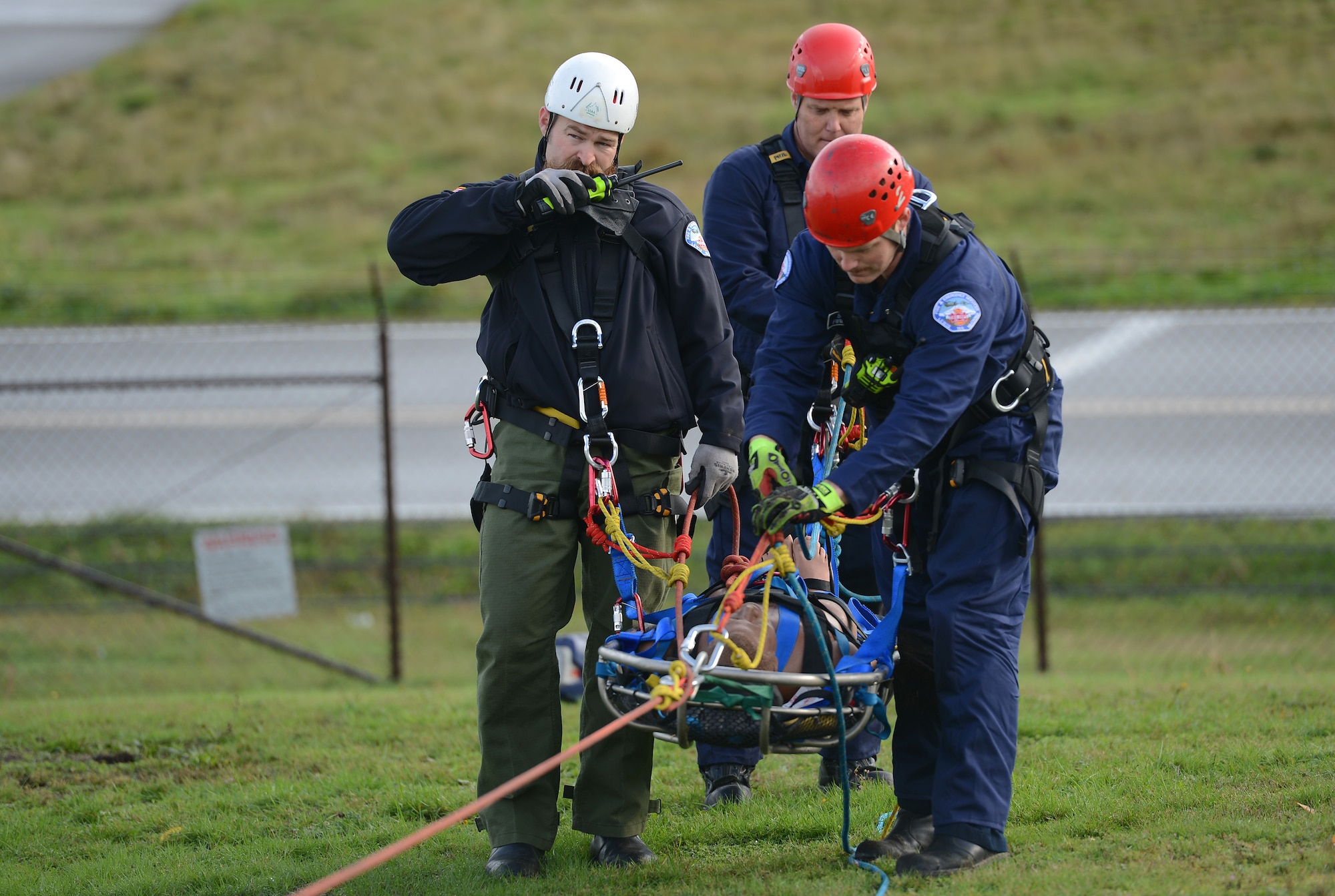 Brandon Green (left), Joint Base Lewis-McChord Fire and Emergency Services firefighter, radios for transportation of a simulated patient during low-angle rescue training Oct. 17, 2016, at Joint Base Lewis-McChord, Wash. The training allowed firefighters to practice using rope systems, patient care and patient packaging. (U.S. Air Force photo/Senior Airman Jacob Jimenez)   