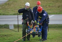 Brandon Green (left), Joint Base Lewis-McChord Fire and Emergency Services firefighter, radios for transportation of a simulated patient during low-angle rescue training Oct. 17, 2016, at Joint Base Lewis-McChord, Wash. The training allowed firefighters to practice using rope systems, patient care and patient packaging. (U.S. Air Force photo/Senior Airman Jacob Jimenez)   