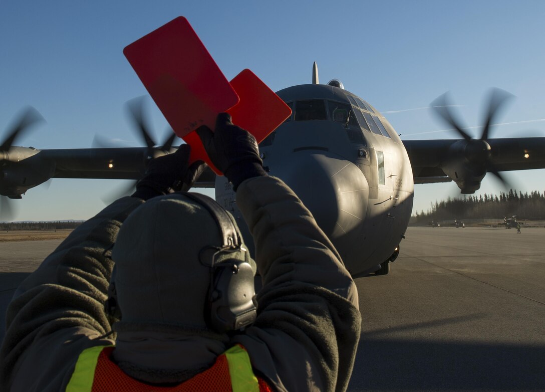 U.S. Air Force Staff Sgt. Brian Hodge, 921st Contingency Response Squadron ramp coordinator, marshalls a C-130J Super Hercules aircraft at Allen Army Airfield, Alaska during exercise RED FLAG-Alaska 17-1, Oct. 13, 2016. RF-A is a series of Pacific Air Forces commander-directed field training exercises for U.S. and partner nation forces, providing combined offensive counter-air, interdiction, close air support, and large force employment training in a simulated combat environment. (U.S. Air Force photo by Master Sgt. Joseph Swafford)