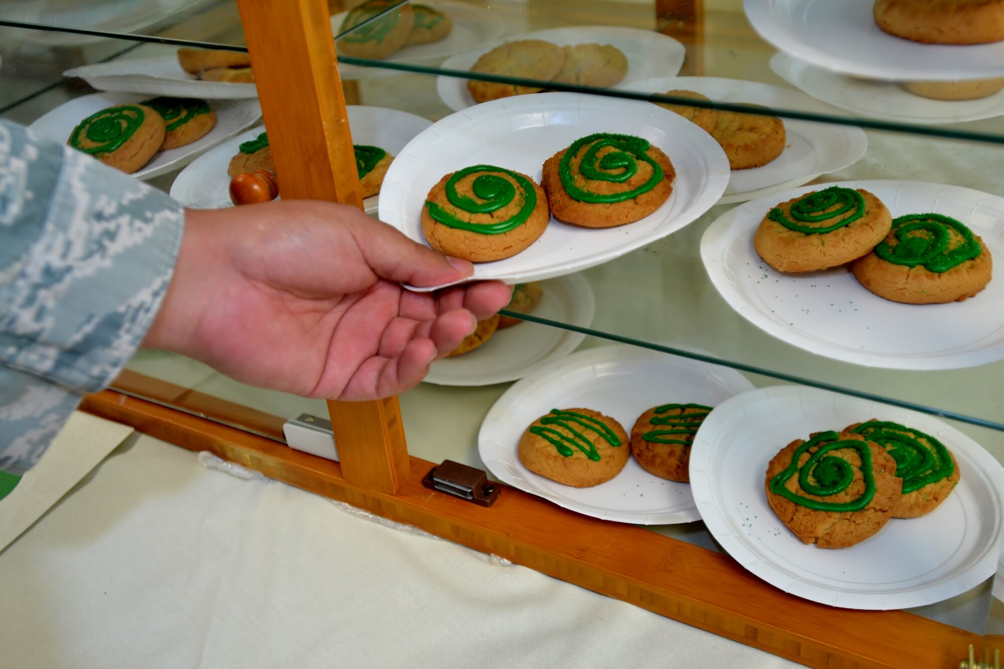 A member of the 111th Attack Wing takes one of the green-iced cookies as part of the Wing’s Green Dot program reminder event at Horsham Air Guard Station, Pa. Oct. 15, 2016. Green Dot is a program used to train all active duty, Reserve and National Guard Airmen in being effective bystanders by stepping in and stopping possible assaults. (U.S. Air National Guard photo by Tech. Sgt. Andria Allmond)
