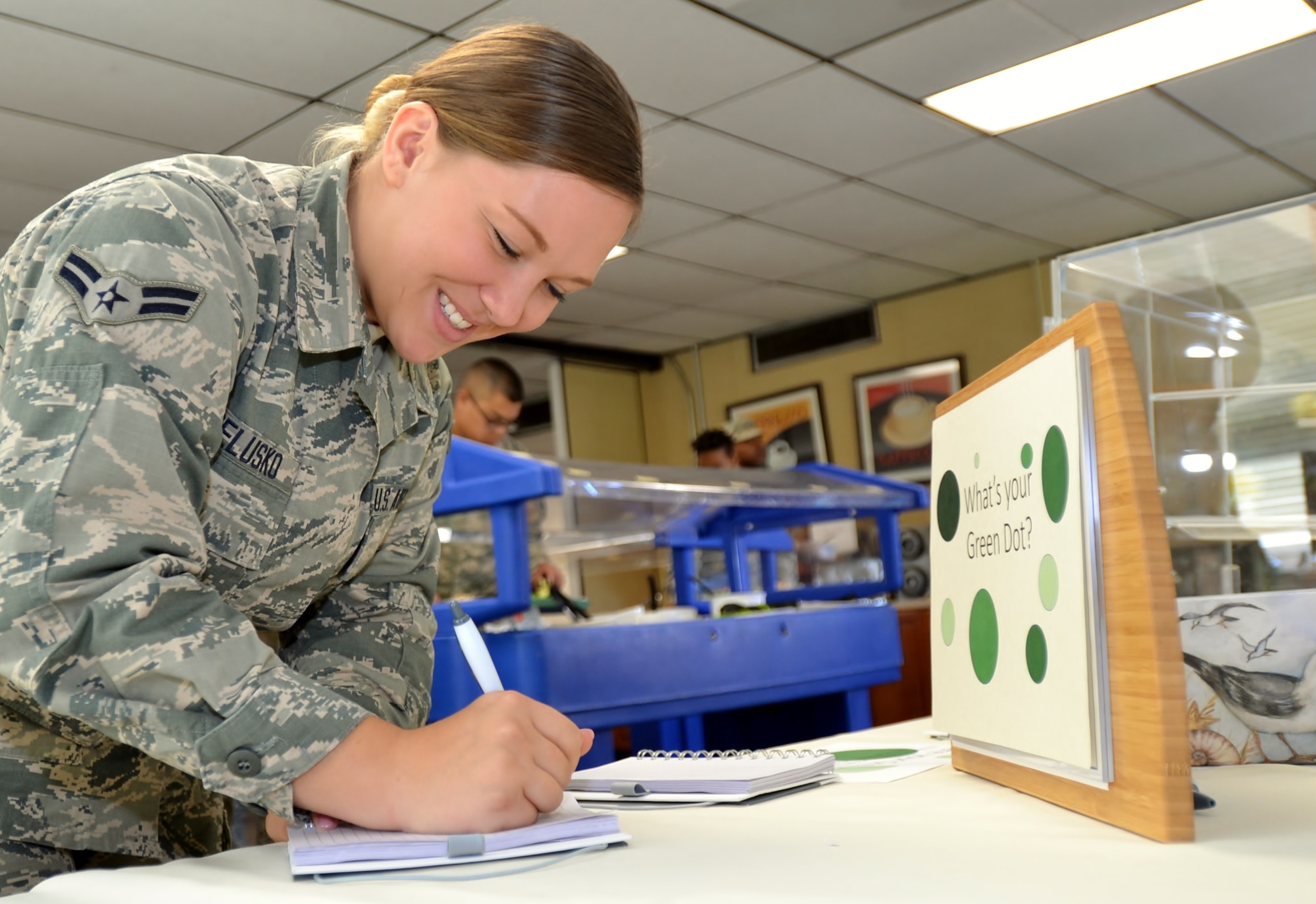 Senior Airman Shawna Belusko, 111th Logistics Readiness Squadron, participates in a Green Dot reminder event hosted by the 111th Force Support Squadron Services Flight and 111th Attack Wing Green Dot program implementers in the dining facility at Horsham Air Guard Station, Pa. Oct. 15, 2016. The program offered green-iced cookies alongside the opportunity for members to write own down their Green Dot experiences. (U.S. Air National Guard photo by Tech. Sgt. Andria Allmond)