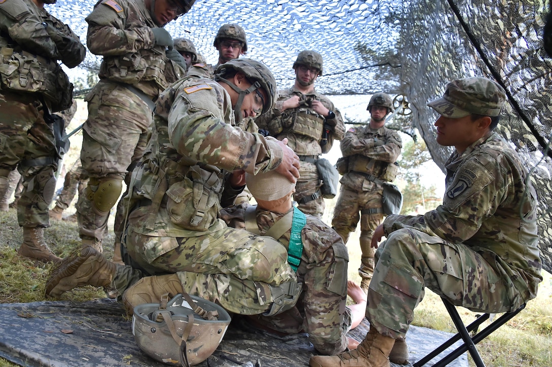 Soldiers train to apply first aid for an open head wound during the Expert Infantryman Badge training at the 7th Army Training Command’s Grafenwoehr Training Area, Germany, Oct. 17, 2016. The purpose of the Expert Infantryman Badge is to recognize Infantrymen who have demonstrated a mastery of critical tasks that build the core foundation of individual proficiency that enables them to locate, close with, and destroy the enemy through fire and maneuver and repel an enemy assault in close combat. Army photo by Gertrud Zach