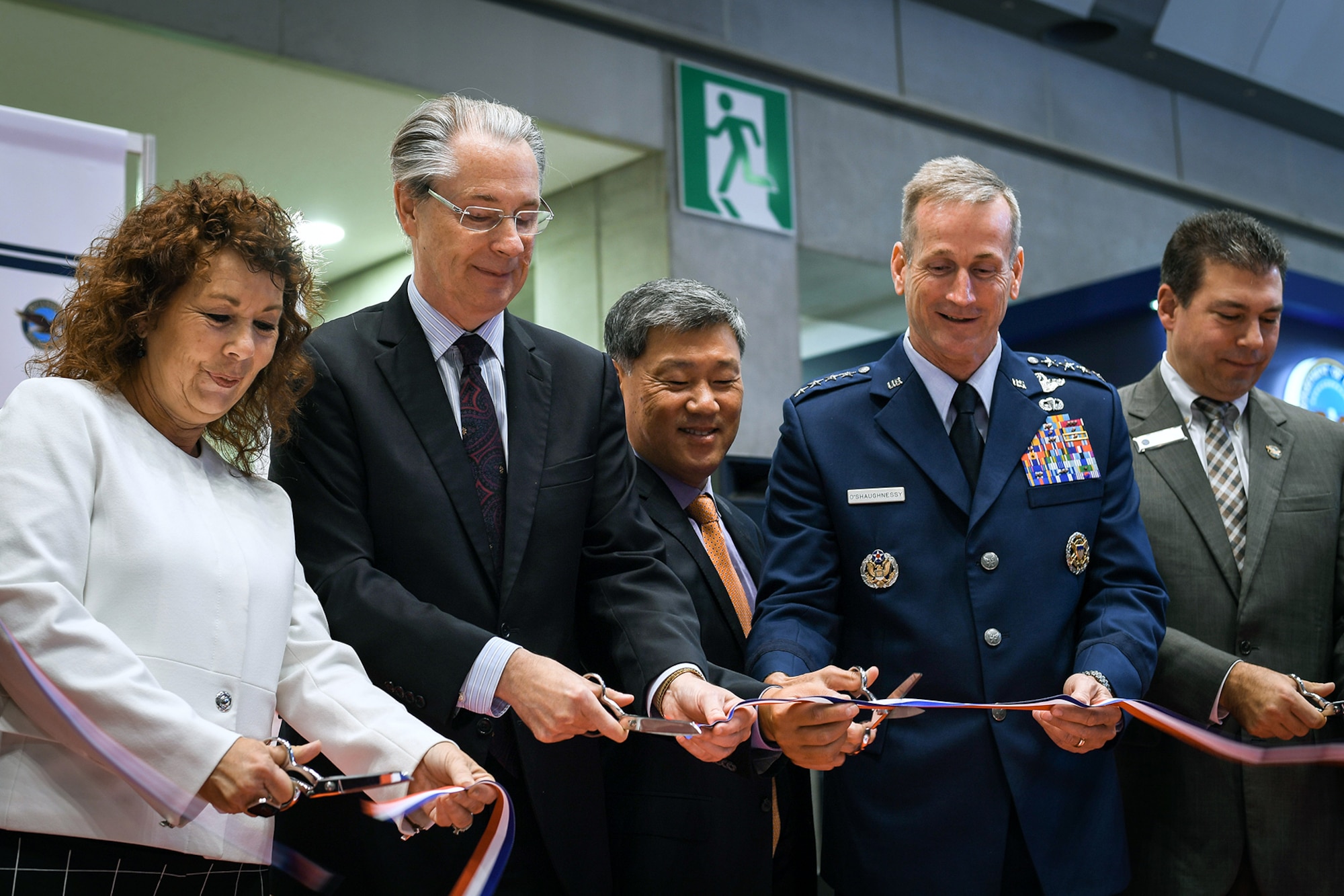 (From Left) Gerri Cozic, Kallman Wolrdwide vice president, Jason Hyland, Deputy Chief of Mission Remarks and U.S. Air Force Gen. Terrence O’Shaughnessy, Pacific Air Force commander, cut the ribbon at the opening ceremony of the U.S. Booth at the Japan Aerospace Exhibition in Tokyo, Japan, Oct. 12, 2016. With 792 Japanese and international companies, the event displayed commercial and military technology, from new air turbine components to a life-sized display of an F-35. (U.S. Air Force photo by Staff Sgt. Michael Smith)