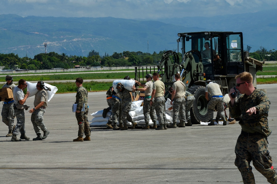 Service members attached to Joint Task Force Matthew prepare to load supplies onto a MV-22B Osprey assigned to Marine Medium Tiltrotor Squadron 365 for delivery in Port-au-Prince, Haiti, Oct. 17, 2016. JTF Matthew is providing humanitarian aid and disaster relief to Haiti following Hurricane Matthew. Navy photo by Petty Officer 3rd Class Jess E. Toner