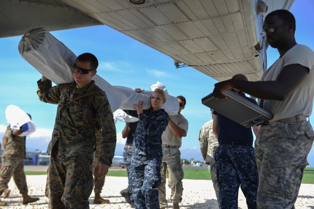 Service members attached to Joint Task Force Matthew load supplies onto a CH-53E Super Stallion helicopter assigned to Marine Medium Tiltrotor Squadron 365 for delivery in Port-au-Prince, Haiti, Oct. 17, 2016. JTF Matthew is providing humanitarian aid and disaster relief to Haiti following Hurricane Matthew. Navy photo by Petty Officer 2nd Class Andrew Murray