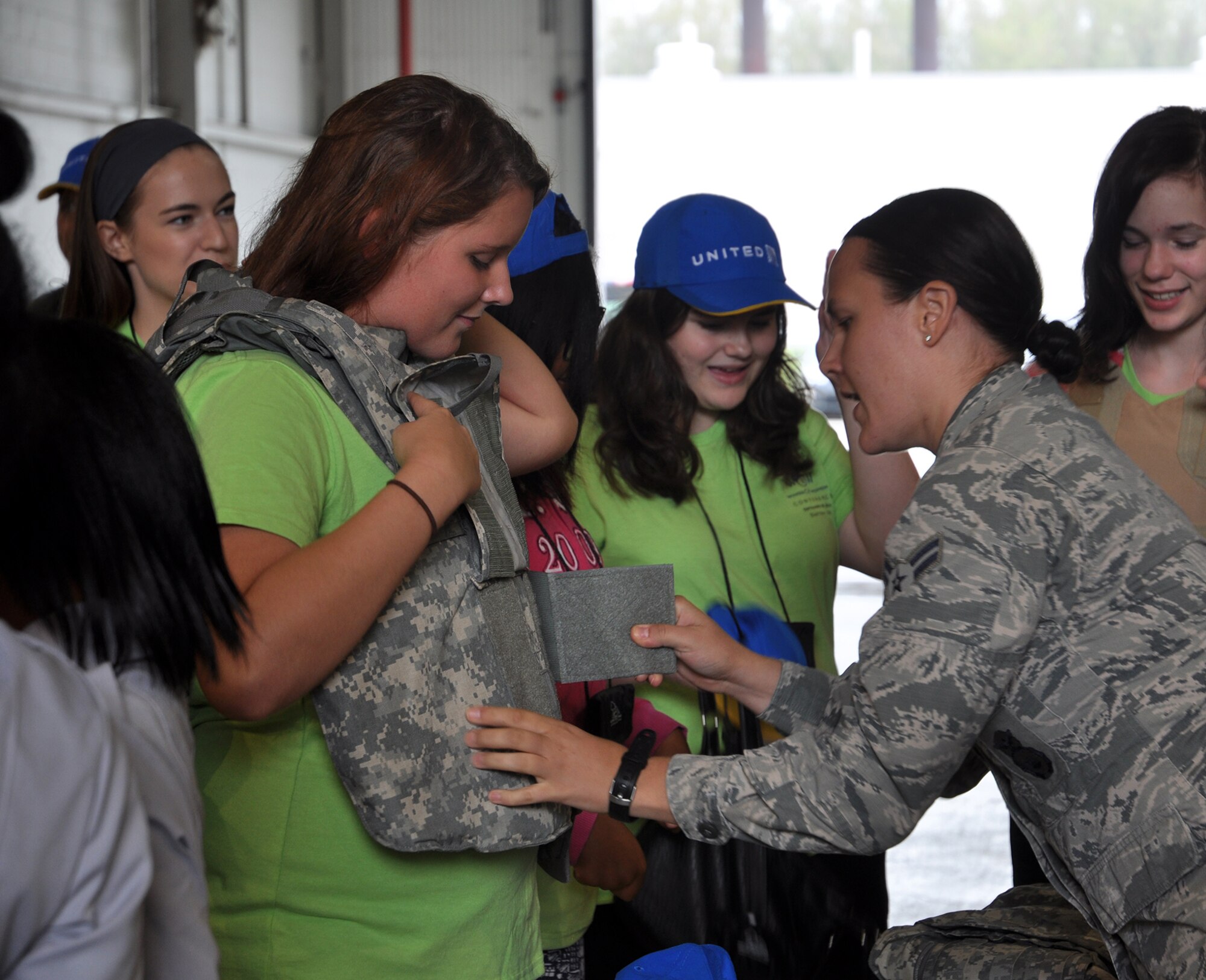 Airman 1st Class Paula Dennis, 445th Security Forces Squadron, lets a student attending the Wings of Women Conference try on some of their protective equipment during the security forces demonstration portion of the Wings of Women Conference held at the 445th Airlift Wing Sept. 30, 2016. (U.S. Air Force photo/Staff Sgt. Rachel Ingram)
