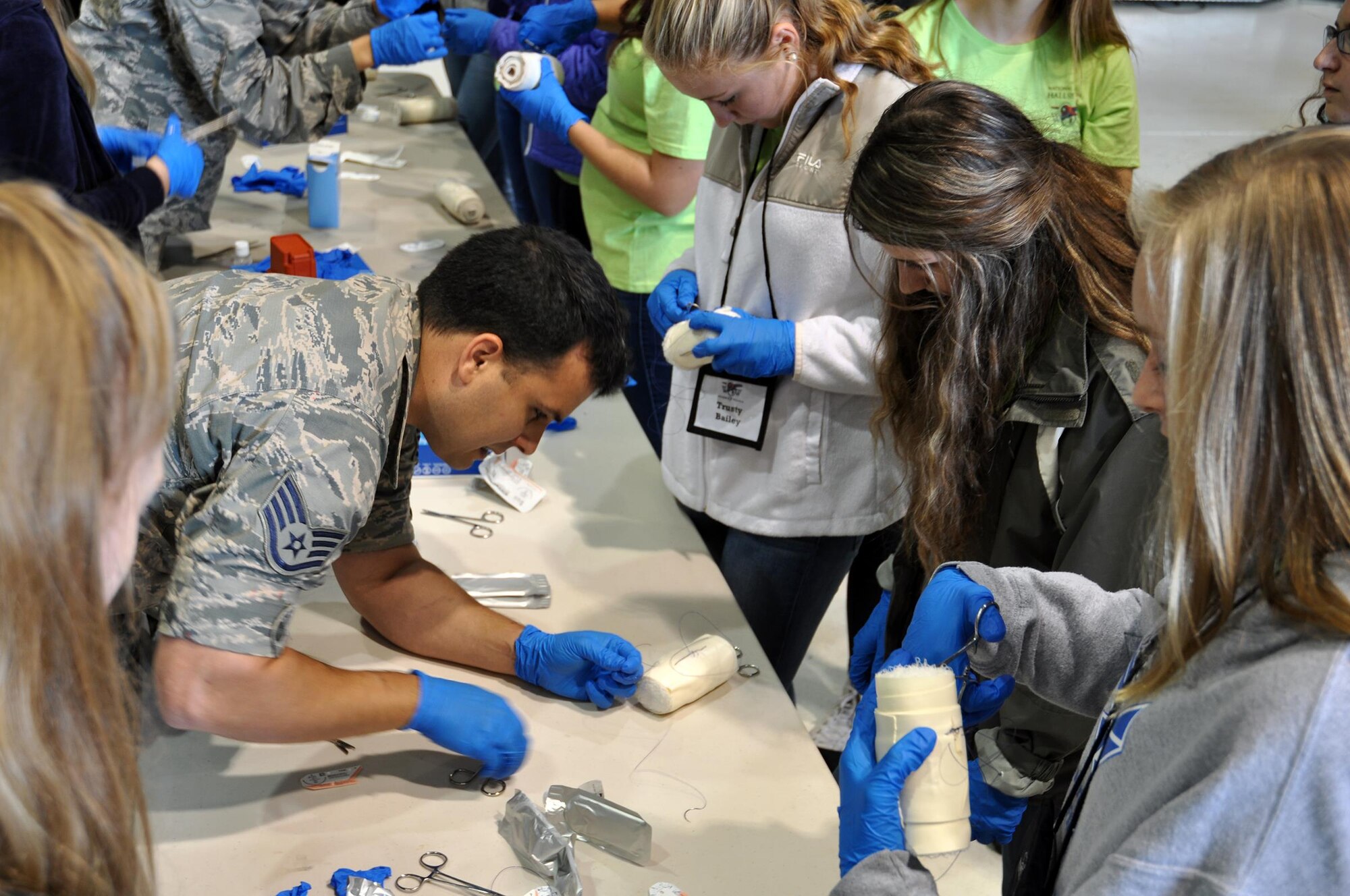 Staff Sgt. Christopher Bock-Bacalao, 445th Aerospace Medicine Squadron, shows how to perform a suture using gauze to simulate a patient during a demonstration by AMDS for students attending the Wings of Women Conference held at the 445th Airlift Wing Sept. 30, 2016. (U.S. Air Force photo/Staff Sgt. Rachel Ingram)