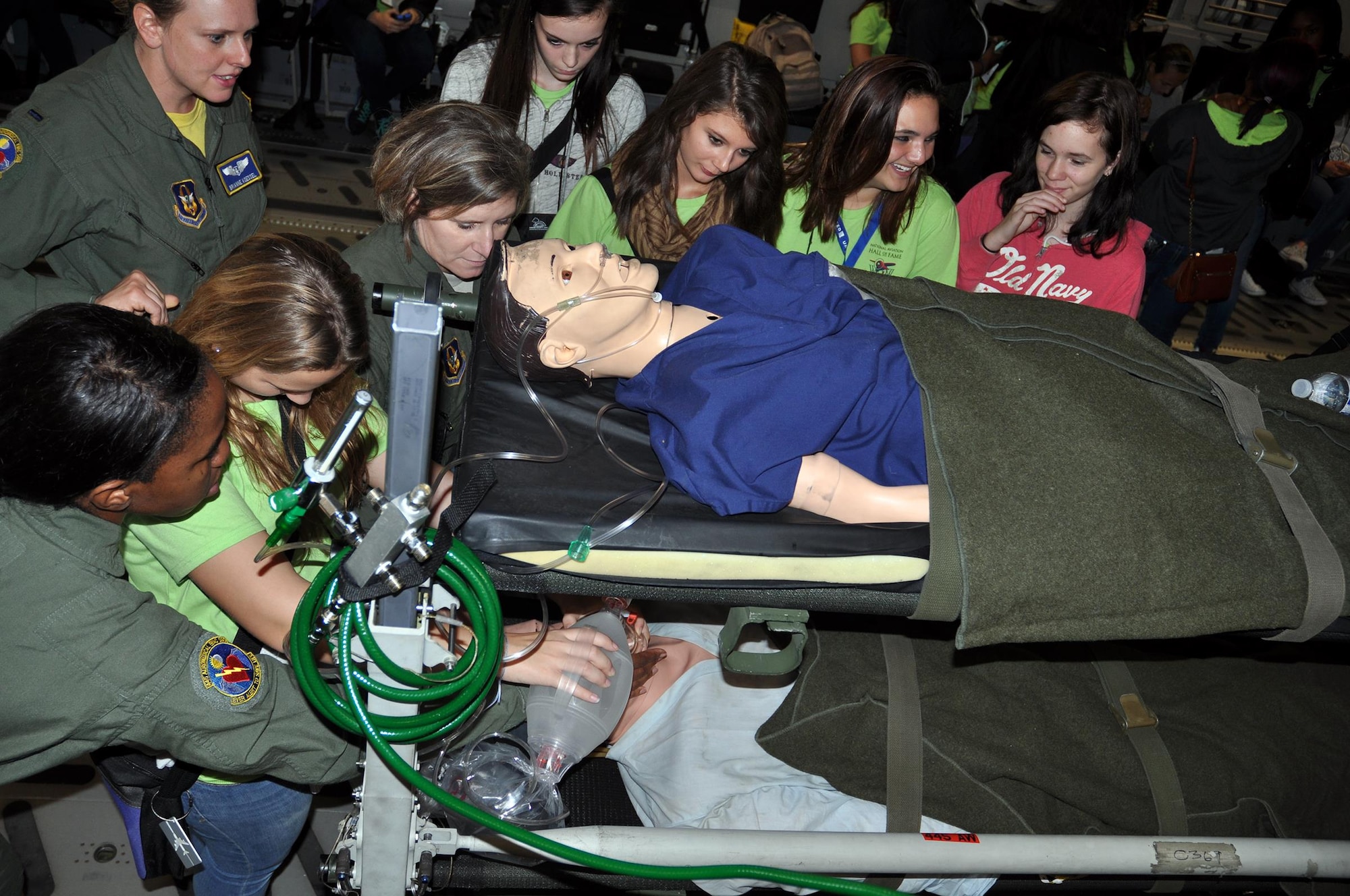 Airmen from the 445th Aeromedical Evacuation Squadron show students attending the Wings of Women Conference how they treat patients while on a flying mission during an AE demonstration on board a static 445th Airlift Wing C-17 Globemaster III Sept. 30, 2016. (U.S. Air Force photo/Staff Sgt. Rachel Ingram)