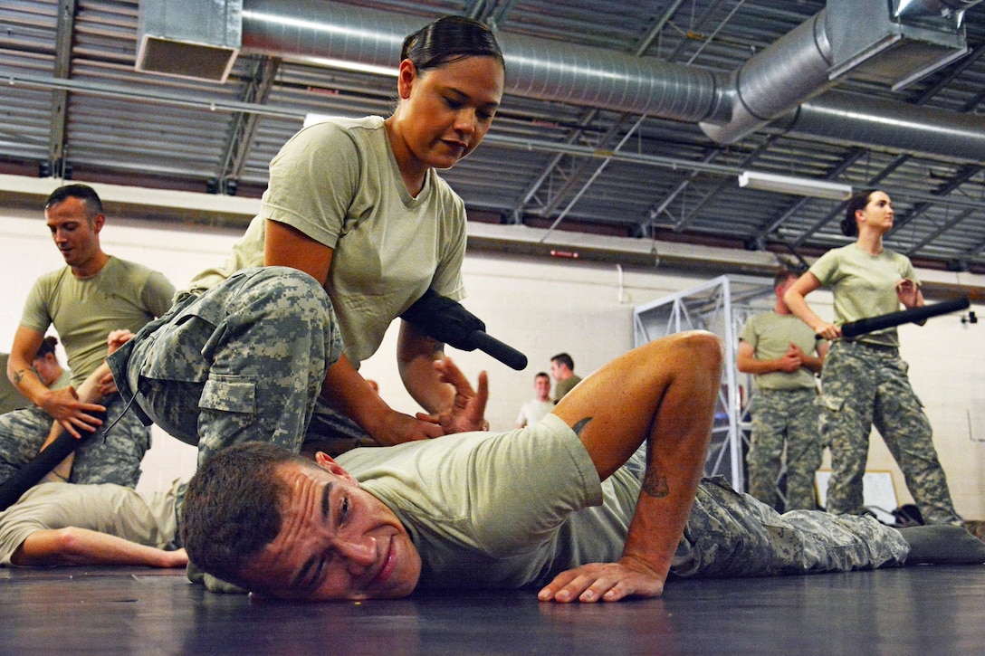 U.S. Army reservists Sgt. Michele Barrera and Spc. George Knighting from the 414th Military Police Company headquartered in Joplin, Mo., practice various baton techniques as part of the company’s law enforcement integration and certification training provided by U.S. Army MP Soldiers from the 728th MP Battalion, 8th MP Brigade, 8th Theater Sustainment Command, Sept. 4-28 at Schofield Barracks, Hawaii. (U.S. Army photo by Staff Sgt. Taresha Hill, 8th Military Police Brigade Public Affairs, 8th Theater Sustainment Command)