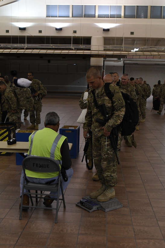 Soldiers assigned to the 305th Engineer Facility Detachment and the 785th Military Police Battalion, both Army Reserve units, are weighed, manifested and processed prior to boarding a flight to the U.S. Central Command at the Silas L. Copeland Arrival/Departure Airfield Control Group here Oct. 3. Photos by Ismael Ortega, Mobilization and Deployment, DPTMS Public Affairs.