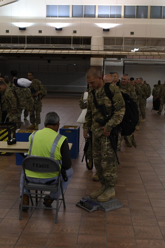 Soldiers assigned to the 305th Engineer Facility Detachment and the 785th Military Police Battalion, both Army Reserve units, are weighed, manifested and processed prior to boarding a flight to the U.S. Central Command at the Silas L. Copeland Arrival/Departure Airfield Control Group here Oct. 3. Photos by Ismael Ortega, Mobilization and Deployment, DPTMS Public Affairs.