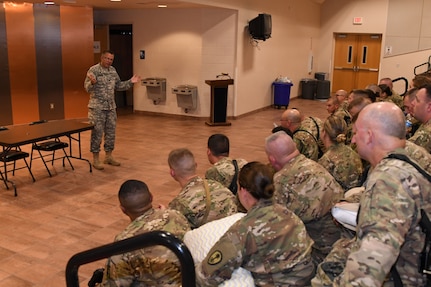 (Left) Capt. Jaime Corson, chaplain, Mobilization and Deployment, Directorate of Plans, Training, Mobilization and Security, Fort Bliss Garrison speaks to Soldiers assigned to the 305th Engineer Facility Detachment and the 785th Military Police Battalion, both U.S. Army prior to boarding a flight to the U.S. Central Command at the Silas L. Copeland Arrival/Departure Airfield Control Group here Oct. 3.