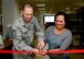 Command Chief Master Sgt. Matt Lusson, 31st Fighter Wing command chief and Lyly Granfield, Airman’s Attic volunteer, cut the ribbon during the Airman’s Attic reopening at Aviano Air Base, Italy, Oct. 17, 2016. During its two-week closure, volunteers remodeled, restocked and filtered through donations in order to provide the best products to customers. (U.S. Air Force photo by Senior Airman Areca T. Bell/Released)