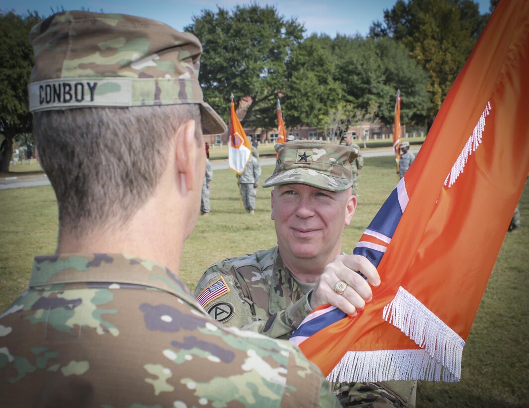 Brig. Gen. (Promotable) Peter A. Bosse, incoming commander for the 335th Signal Command (Theater) takes the 335th SC (T) flag from Maj. Gen. David J. Conboy, the deputy commanding general (operational), United States Army Reserve Command symbolizing the official transfer of authority during a change of command ceremony at Fort McPherson, Georgia, Oct. 15.  Bosse took command from Brig. Gen. Christopher R. Kemp, who had commanded the unit and it's more than 4,500 Soldiers for the past two years.