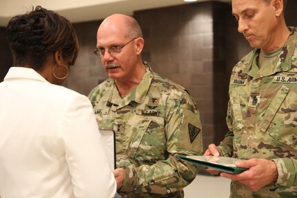 Maj. Gen. William Lee and Command Sgt. Maj. Robert Boudnik present an award to Mrs. Graham in honor of Master Sgt. Steven Graham during the memorial ceremony, Oct. 15, 2016.  Photo captured by Maj. Satomi Mack-Martin.