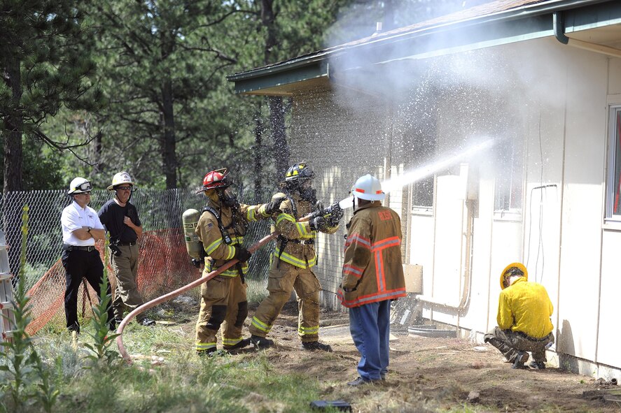 Firefighters from the 10th Civil Engineer Squadron Fire Department douse a structure during a fire-response exercise at the U.S. Air Force Academy. Academy firefighters will compete in the Firefighter Would Championship beginning Oct. 24, 2016 in Montgomery, Alabama. (U.S. Air Force photo/Jason Gutierrez)