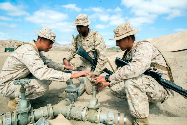 U.S. Marine Corps Cpl. Samuel Ruizlopez, from Aberdeen, Washington, a bulk fuel specialist with Bulk Fuel Company, 7th Engineer Support Battalion, instructs Pfc. Jonathan Arevalo, from Brooklyn, New York, and Pfc. Carlos Effiogalvez, from New York City, how to turn valves to control water flow into a 50,000 gallon bag during the bulk fuel Marine Corps Combat Readiness Evaluation on Camp Pendleton, Calif., Oct. 12, 2016. By using water from Lake O’Neill, the Marines were able to simulate the process of pumping fuel from ship to shore in an expeditionary environment.