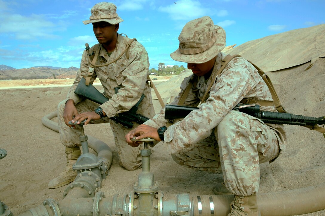 U.S. Marine Corps Pfc. Jonathan Arevalo, from Brooklyn, New York, and Pfc. Carlos Effiogalvez, from New York City, both bulk fuel specialists with Bulk Fuel Company, 7th Engineer Support Battalion, operate valves to control the water flow into a 50,000 gallon bag during the bulk fuel Marine Corps Combat Readiness Evaluation on Camp Pendleton, Calif., Oct. 12, 2016. The MCCRE provides the Marines of 7th ESB with a training opportunity that helps them polish their skills with hands-on operations to increase their combat readiness.