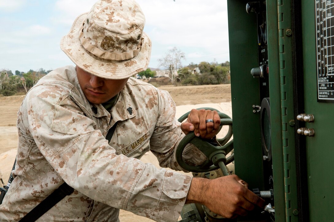 U.S. Marine Corps Sgt. Oscar Tapia, from Salinas, Calif., a bulk fuel specialist with Bulk Fuel Company, 7th Engineer Support Battalion, controls the water pressure of a 600-gallon-per-minute pump while it flows through a 6-inch hose reel system into one of the 50,000 gallon bags at the storage site during the bulk fuel Marine Corps Combat Readiness Evaluation on Camp Pendleton, Calif., Oct. 12, 2016. There are three 200,000 gallon storage sites totaling 600,000 gallons in the MCCRE as well as two 120,000 gallon sites.