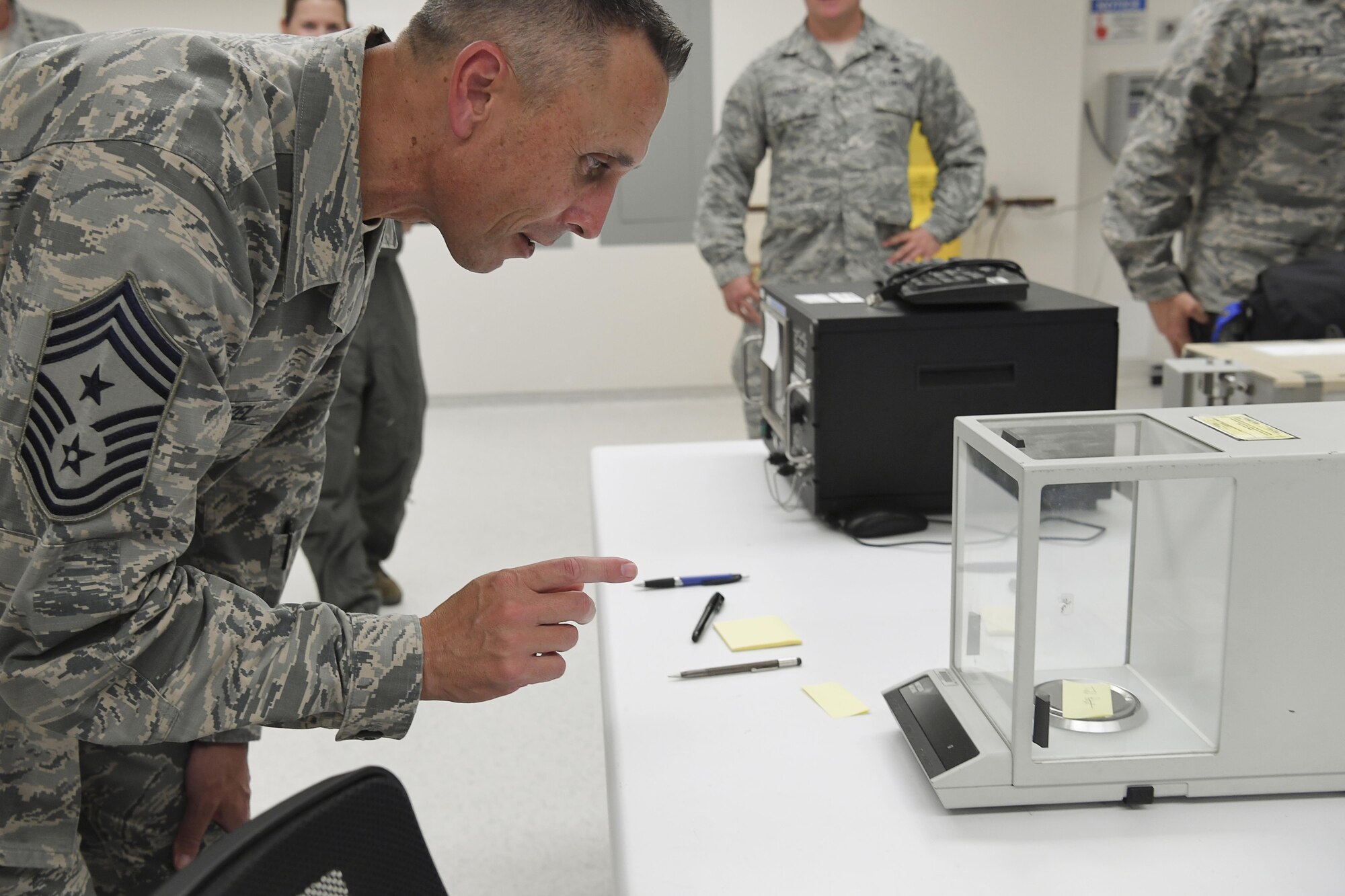 Chief Master Sgt. Todd Petzel, 18th AF command chief, sees what kind of weight his signature carries using an analytic balance while touring the 305th Maintenance Squadron’s Precision Measurement Equipment Laboratory Oct. 12. The lab is responsible for the measurement, calibration and diagnostics of over 14,000 pieces of equipment annually, making it one of the larger PMELs in the Air Force. (U.S. Air Force photo by Christian DeLuca/released)
