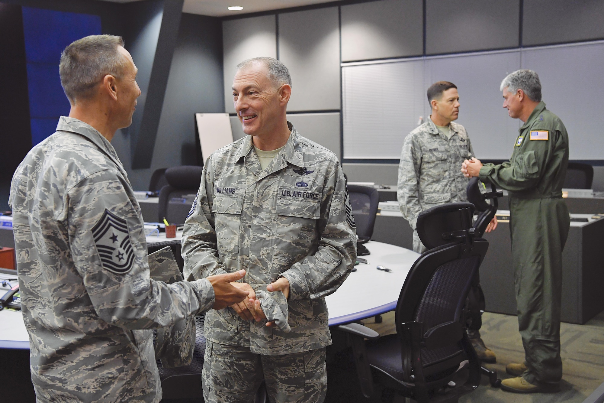 Chief Master Sgt. Todd Petzel, 18th AF command chief, talks with Chief Master Sgt. Larry Williams, U.S. Air Force Expeditionary Center command chief, as Lt. Gen. Sam Cox, 18th Air Force commander, and Brig. Gen. Stephen Oliver, U.S. Air Force Expeditionary Center vice commander speak in the background, after a briefing at the Joint Base McGuire-Dix-Lakehurst command post. (U.S. Air Force photo by Christian DeLuca/released)

