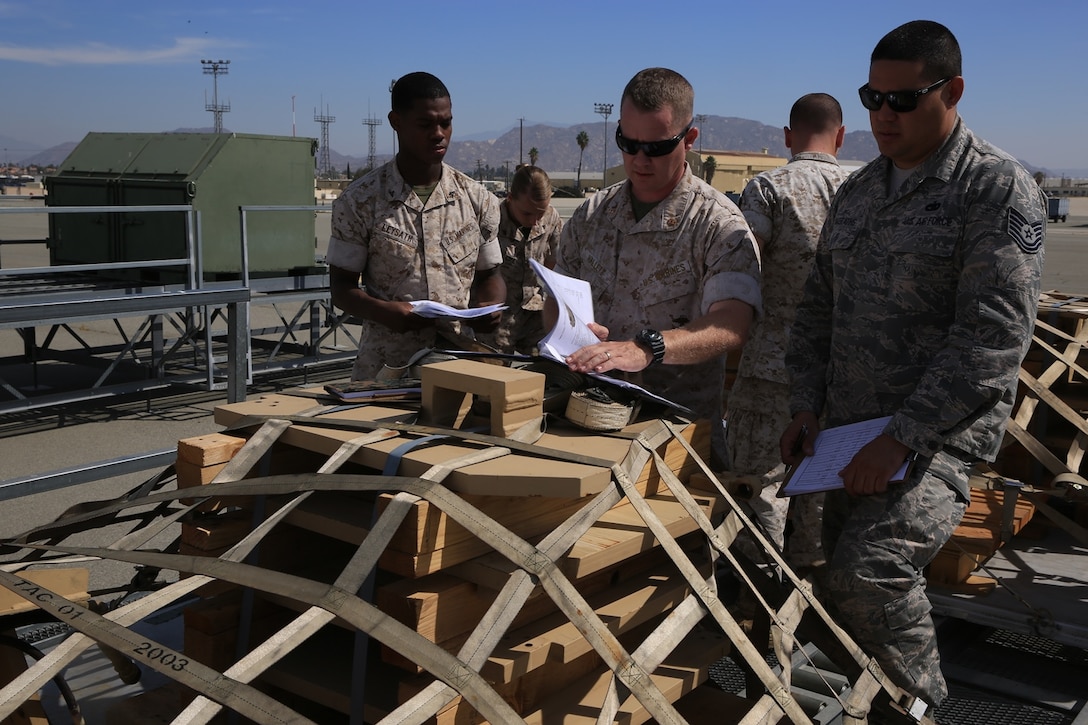 U.S. Marine Corps Lance Cpl. Bryson Leysath, Chief Warrant Officer 2 Robert Hallett and U.S. Air Force Tech. Sgt. Geoffrey Gaeraths inspect pallets containing M-88A2 HERCULES equipment at March Air Force Reserve Base, Calif., Oct. 13, 2016. Leysath, from Augusta, Ga., is an embarkation specialist with Combat Logistics Regiment 15, Hallett, from Mesa, Az., is a mobility officer with CLR 15 and Gaeraths, from Victorville, Calif., is a joint inspector with 452nd Logistics Readiness Squadron.