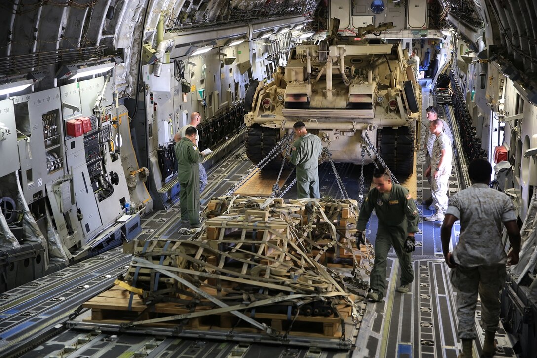 U.S. Marines and Airmen work together to properly secure the M-88A2 HERCULES and pallets in the C-17 Globemaster III at March Air Force Reserves Base, Calif., Oct. 14, 2016. Marines and Airmen checked all chains and pallets before flying to Marine Corps Air Ground Combat Center Twentynine Palms, Calif.