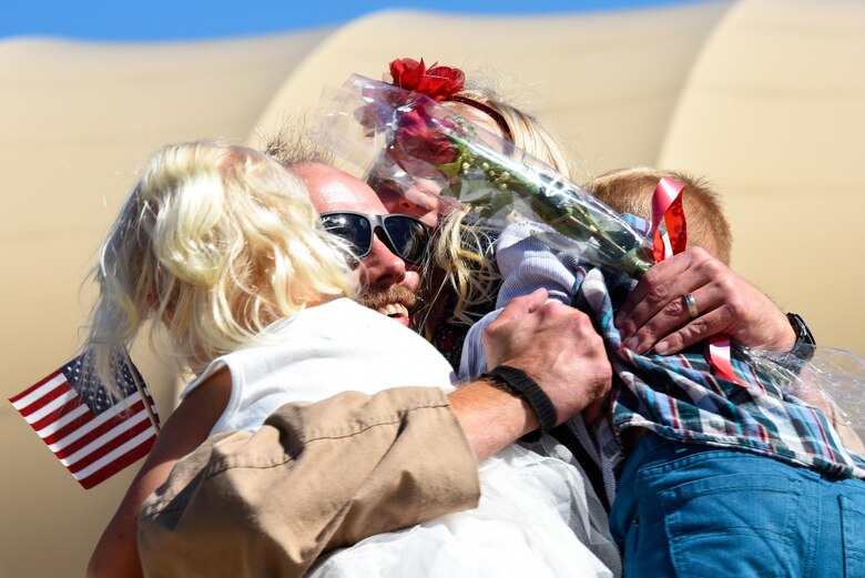 Maj. John Davis, 335th Fighter Squadron weapons system officer, embraces his children upon returning from deployment, Oct. 12, 2016, at Seymour Johnson Air Force Base, North Carolina. More than 150 friends and family greeted the aircrew upon their return from an undisclosed location in Southwest Asia. (U.S. Air Force photo by Airman Shawna L. Keyes)