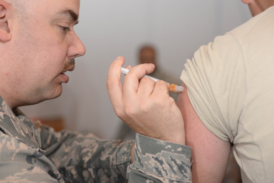 Tech. Sgt. David Holman, 5th Medical Operations Squadron NCO in charge of the personnel reliability assurance program, administers an influenza vaccination to an Airman at Minot Air Force Base, N.D., Oct. 13, 2016. The 5th Medical Group conducted a point of distribution exercise to provide adequate vaccinations in case of a mass-epidemic virus was ever contracted here. (U.S. Air Force photo/Airman 1st Class Jessica Weissman)
