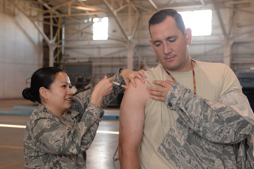 Maj. Jennie Caval, 5th Medical Operations Squadron flight commander, administers an influenza vaccination to Master Sgt. Stephen Pearson, 5th Maintenance Squadron section chief, at Minot Air Force Base, N.D., Oct. 13, 2016. More than 1,400 high-risk personnel, to include pregnant women, anyone over the age of 65 and immunocompromised patients, were administered the vaccination first. (U.S. Air Force photo/Airman 1st Class Jessica Weissman)