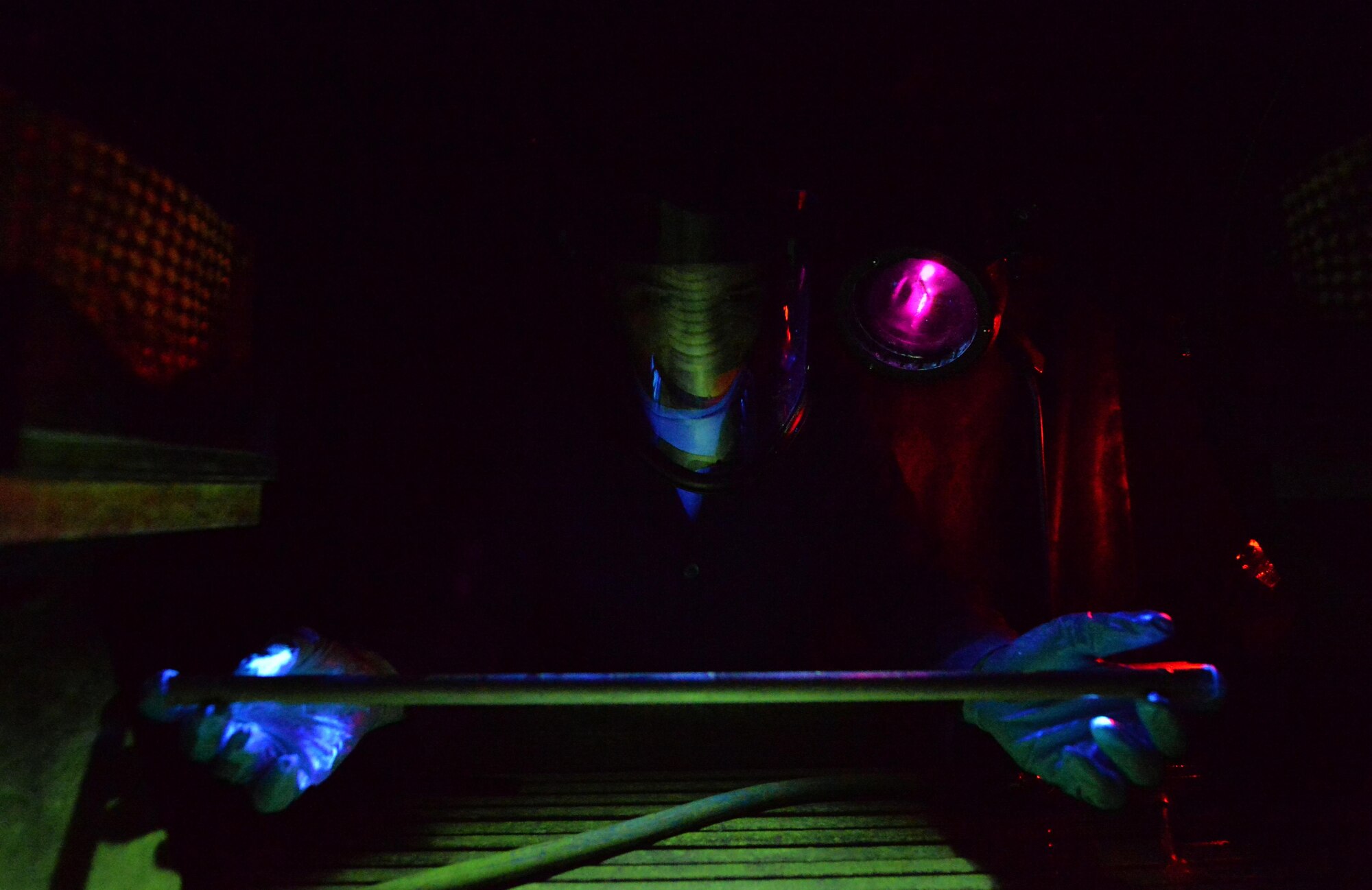 Airman 1st Class Brian Sheldon, a non-destructive inspection journeyman with the 1st Special Operations Maintenance Squadron, stands with a magnetic particle unit at Hurlburt Field Fla., Oct. 17, 2016. A magnetic particle unit blocks light from hitting the prop rod allowing the florescent light to glow indicating imperfections on parts. These specialist use noninvasive methods to inspect the insides of metal objects to identify possible defects in systems and equipment. (U.S. Air Force photo by Senior Airman Andrea Posey)