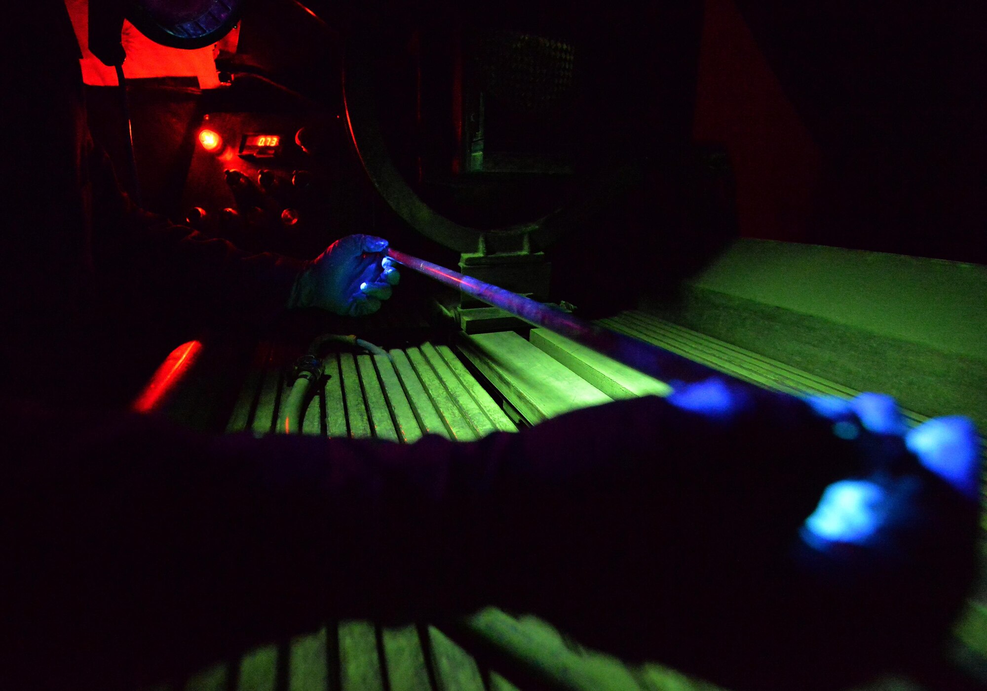 Airman 1st Class Brian Sheldon, a non-destructive inspection journeyman with the 1st Special Operations Maintenance Squadron, stands with a magnetic particle unit at Hurlburt Field Fla., Oct. 17, 2016. A magnetic particle unit blocks light from hitting the prop rod allowing the florescent light to glow indicating imperfections on parts. These specialist use noninvasive methods to inspect the insides of metal objects to identify possible defects in systems and equipment. (U.S. Air Force photo by Senior Airman Andrea Posey)