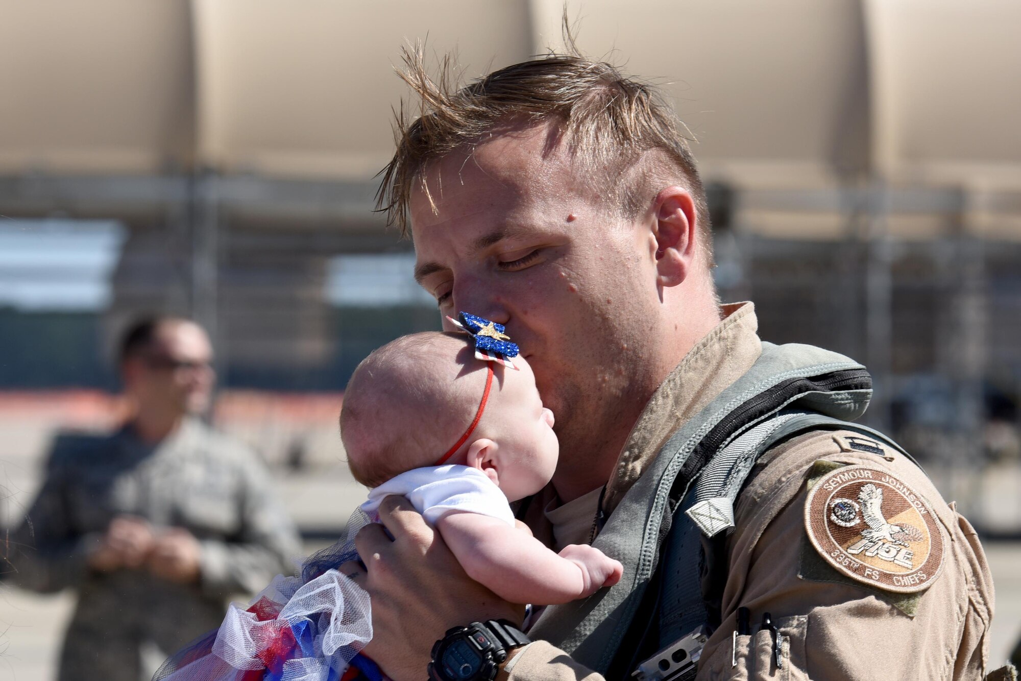 Capt. Skyler Collins, 335th Fighter Squadron pilot, kisses his newborn daughter upon returning home from deployment, Oct. 12, 2016, at Seymour Johnson Air Force Base, North Carolina. Collins met his child for the first time upon his return from deployment in support of OPERATION INHERENT RESOLVE. 