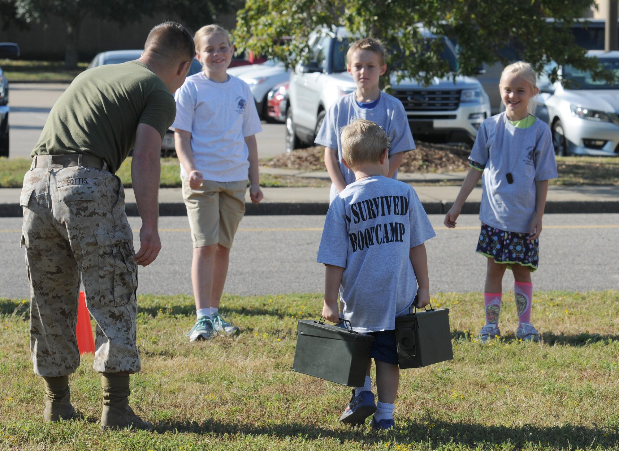 U.S. Marine Pfc. Jonathan Gottis, Keesler Marine Detachment student, assists Jackson Hedin, son of Maj. Cory Hedin, 81st Diagnostic and Therapeutics Squadron pharmacist, with completing a combat fitness test during Operation Hero Oct. 15, 2016, on Keesler Air Force Base, Miss. The event was designed to help children better understand what their parents do when they deploy. (U.S. Air Force photo by Kemberly Groue/Released)