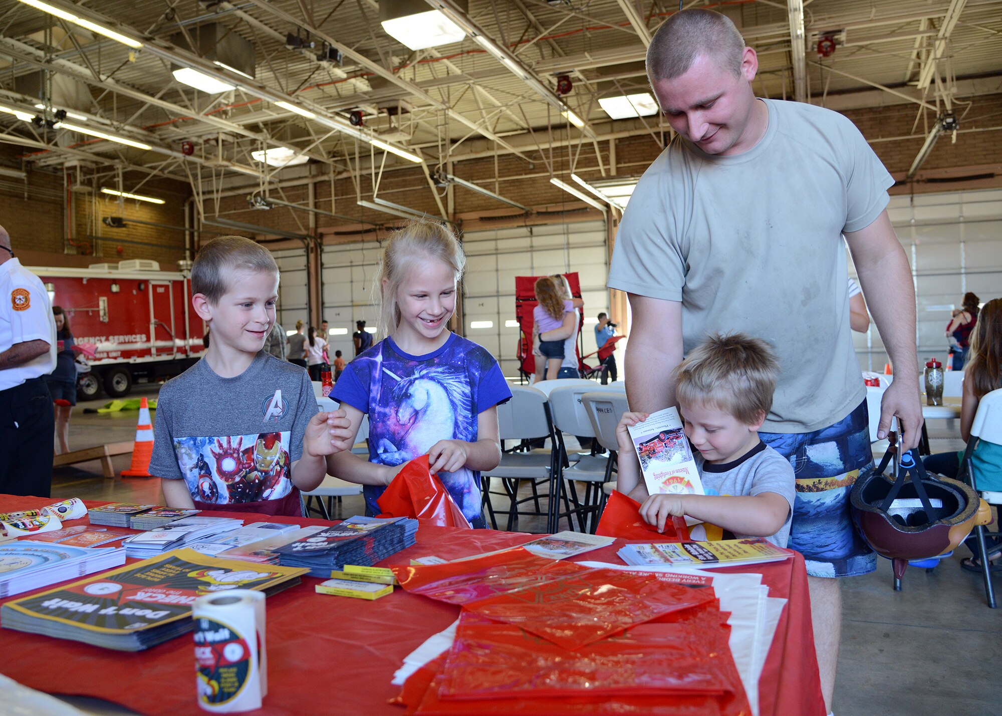 Staff Sgt. Kessler Hamon, 310th Aircraft Maintenance Unit crew chief, helps his kids pick out fire prevention material during the 56th Civil Engineer Squadron fire station open house, Oct. 15, 2016 at Luke Air Force Base, Ariz. The fire station open house was available to the public and featured free food, displays, demonstrations and games for children.(U.S. Air Force photo by Senior Airman Devante Williams)