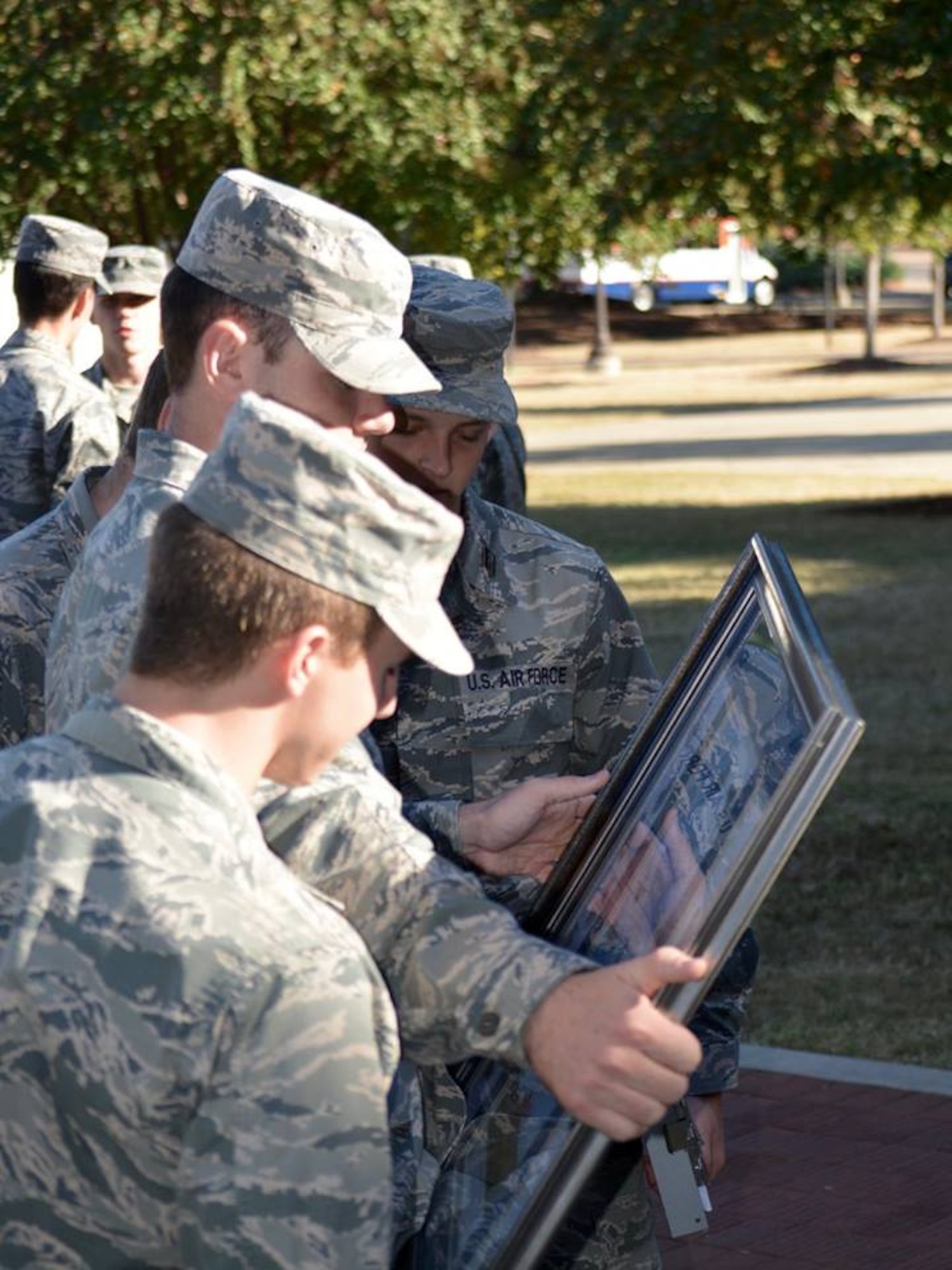 Three Air Force ROTC cadets from Auburn University’s Detachment 005 look at artwork following a career day Oct. 13th at Auburn University. The Gathering of Eagles Foundation presented the ROTC detachment with the framed lithograph, featuring men and women who made lasting contributions to air power, to inspire the cadets as they prepare for a career in the Air Force.  (US Air Force photo by Maj. Will Powell)