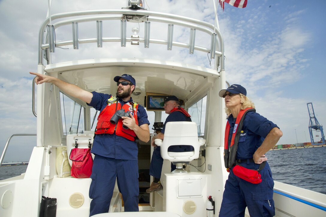 Coast Guard auxiliary members Tim Clarke, left, Don Parker, center, and Dorothy Neiman, all assigned to Flotilla 23-03 in Annapolis, Md., maintain a safety zone for an air show during Maryland Fleet Week in Baltimore, Oct. 16, 2016. Coast Guard photo by Petty Officer 2nd Class Lisa Ferdinando